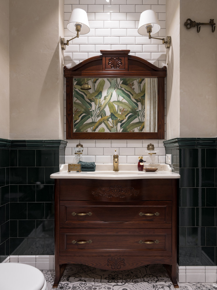 Inspiration pour une salle de bain bohème en bois foncé avec un carrelage vert, un mur beige, un lavabo encastré, un sol multicolore, un plan de toilette beige et un placard avec porte à panneau encastré.