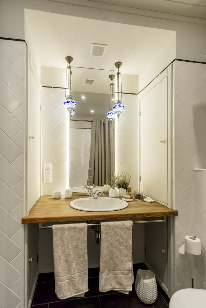 Идея дизайна: маленькая главная ванная комната с душем над ванной, белой плиткой, керамической плиткой, серыми стенами, полом из сланца, накладной раковиной и столешницей из дерева для на участке и в саду