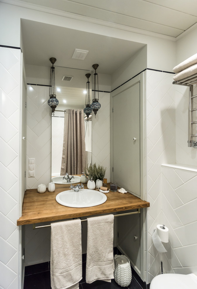Immagine di una piccola stanza da bagno padronale con vasca da incasso, vasca/doccia, WC sospeso, piastrelle bianche, piastrelle in ceramica, pareti grigie, pavimento in ardesia, lavabo da incasso e top in legno