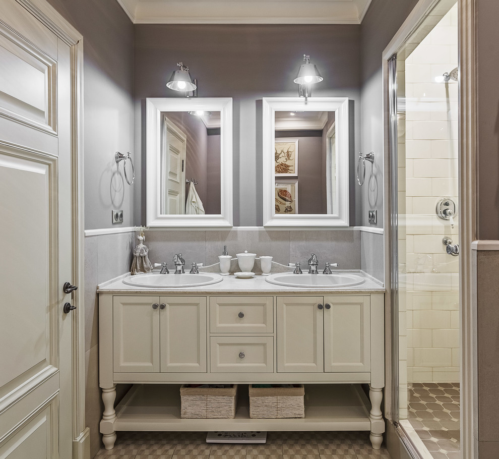 Пример оригинального дизайна: главная ванная комната среднего размера в классическом стиле с фасадами с утопленной филенкой, белыми фасадами, душем в нише, инсталляцией, серой плиткой, керамогранитной плиткой, серыми стенами, полом из керамогранита, столешницей из искусственного камня, накладной раковиной, душем с распашными дверями, ванной в нише, бежевым полом и серой столешницей