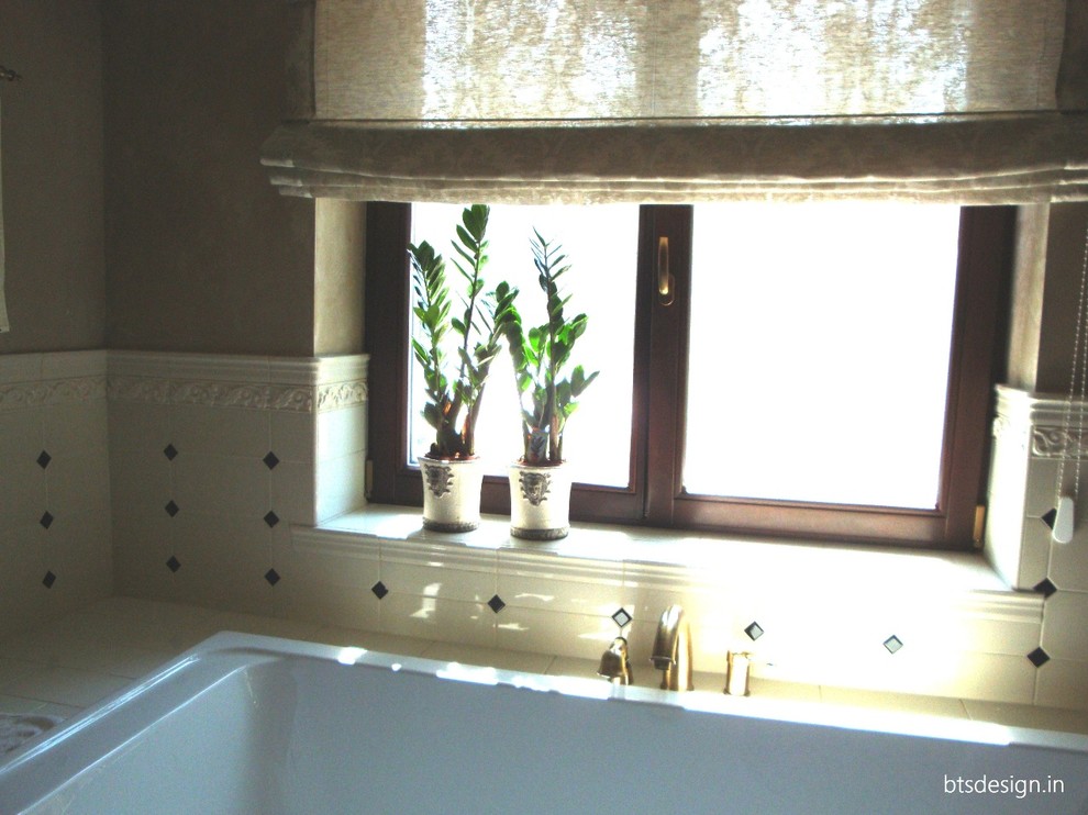 На фото: главная ванная комната среднего размера в стиле неоклассика (современная классика) с фасадами с утопленной филенкой, коричневыми фасадами, полновстраиваемой ванной, инсталляцией, белой плиткой, керамической плиткой, бежевыми стенами, полом из керамической плитки, врезной раковиной, мраморной столешницей и бежевым полом