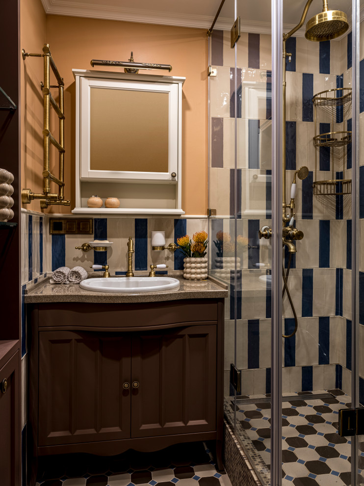 На фото: ванная комната в классическом стиле с фасадами с утопленной филенкой, коричневыми фасадами, душем в нише, разноцветной плиткой, бежевыми стенами, душевой кабиной, накладной раковиной, разноцветным полом, душем с распашными дверями и бежевой столешницей с