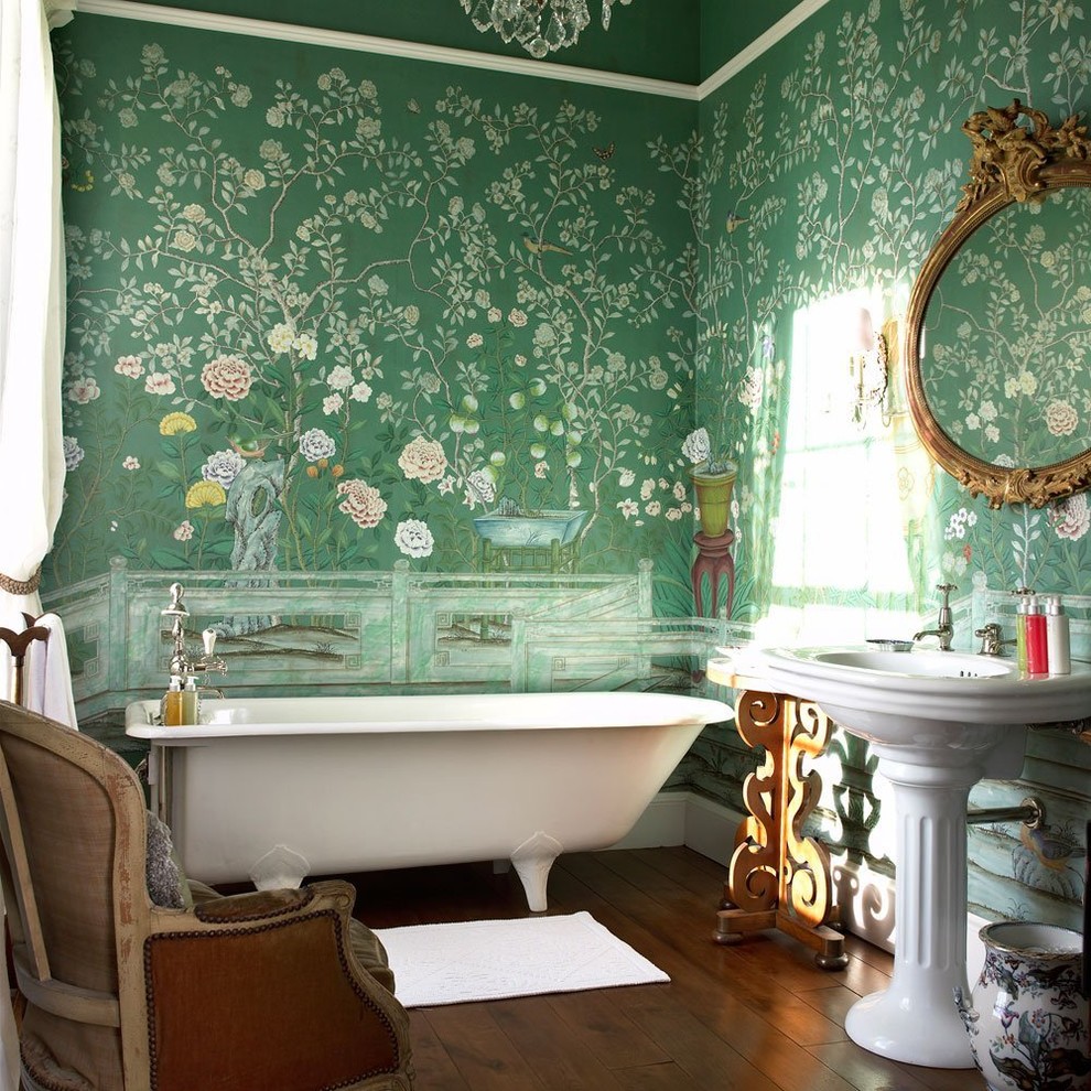 На фото: главная ванная комната в викторианском стиле с ванной на ножках, зелеными стенами, раковиной с пьедесталом и коричневым полом
