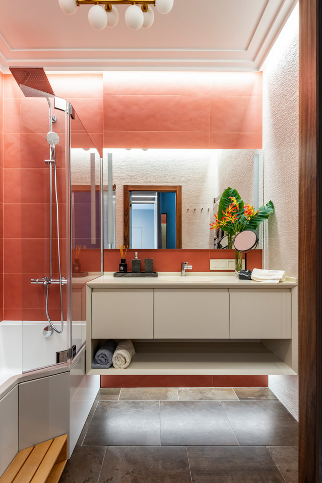 Идея дизайна: ванная комната в современном стиле с плоскими фасадами, ванной в нише, душем над ванной, красной плиткой, бежевой столешницей, бежевыми фасадами, красными стенами и коричневым полом
