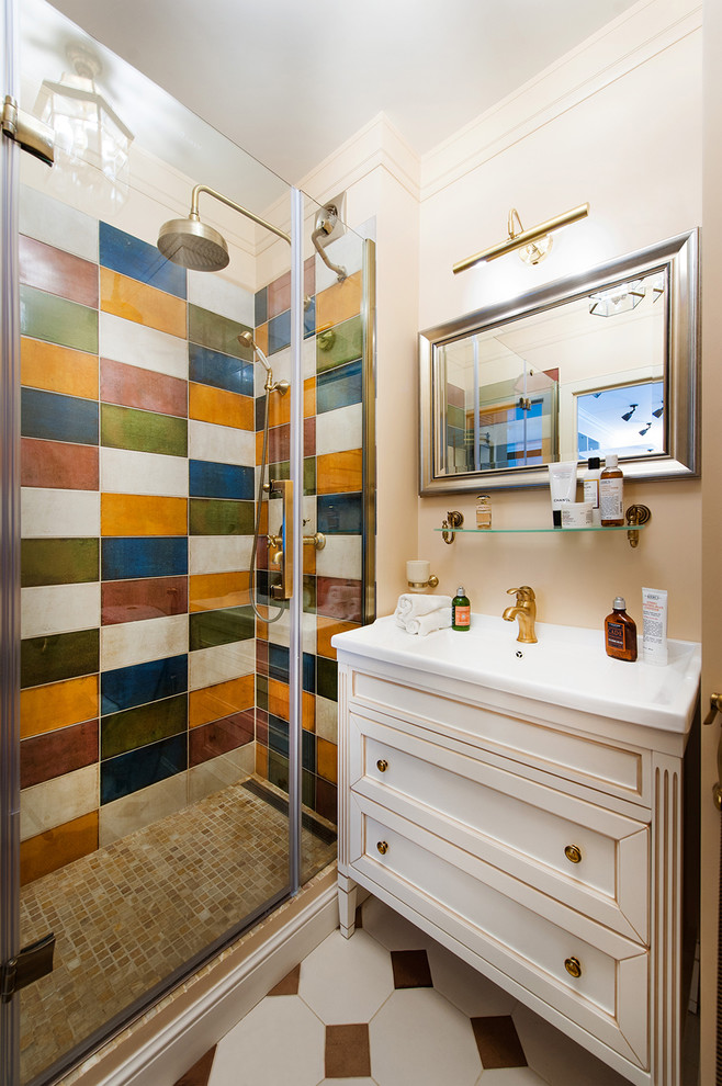 Cette photo montre une salle de bain éclectique avec un plan vasque, des portes de placard blanches, un carrelage multicolore et un placard avec porte à panneau encastré.