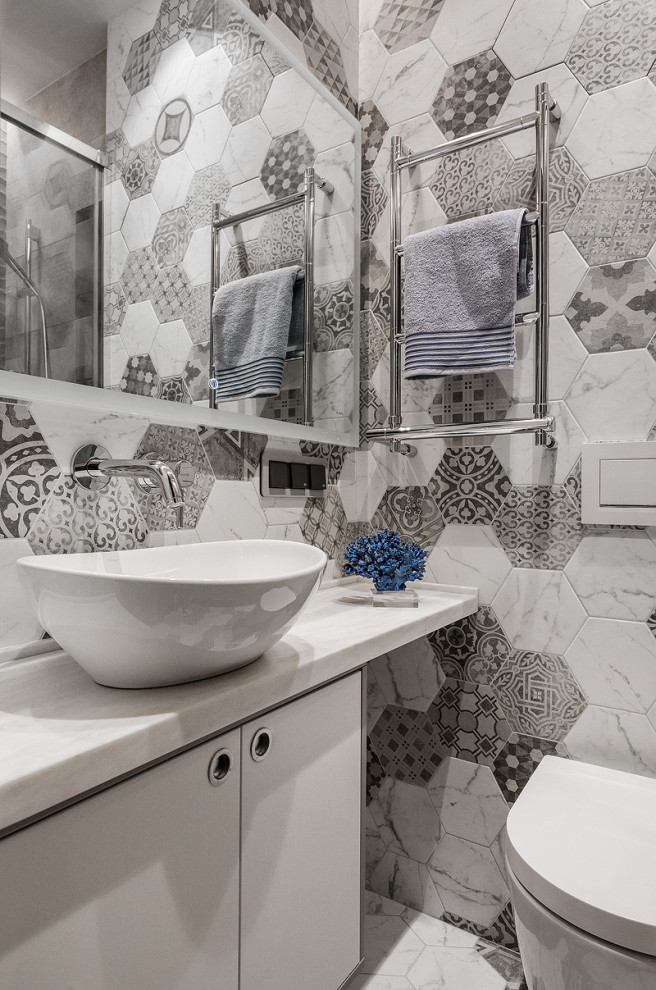 Imagen de cuarto de baño actual con puertas de armario blancas y baldosas y/o azulejos grises