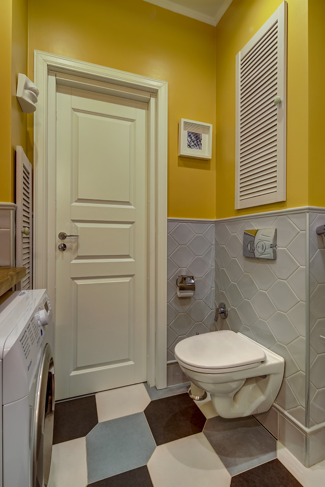 Inspiration för ett funkis badrum, med en vägghängd toalettstol, gula väggar och flerfärgat golv