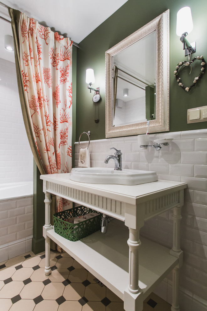 Inredning av ett klassiskt en-suite badrum, med öppna hyllor, vita skåp, ett badkar i en alkov, en dusch/badkar-kombination, vit kakel, tunnelbanekakel, gröna väggar, ett nedsänkt handfat och dusch med duschdraperi