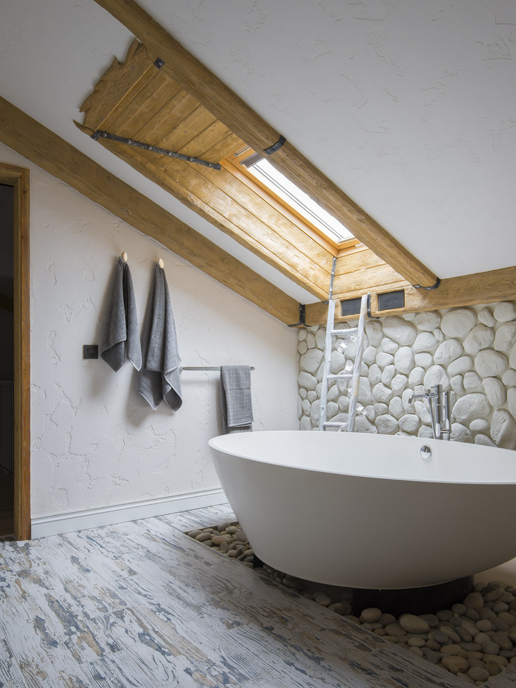 Maritimes Badezimmer En Suite mit beiger Wandfarbe, gebeiztem Holzboden, freistehender Badewanne und Steinwänden in Moskau