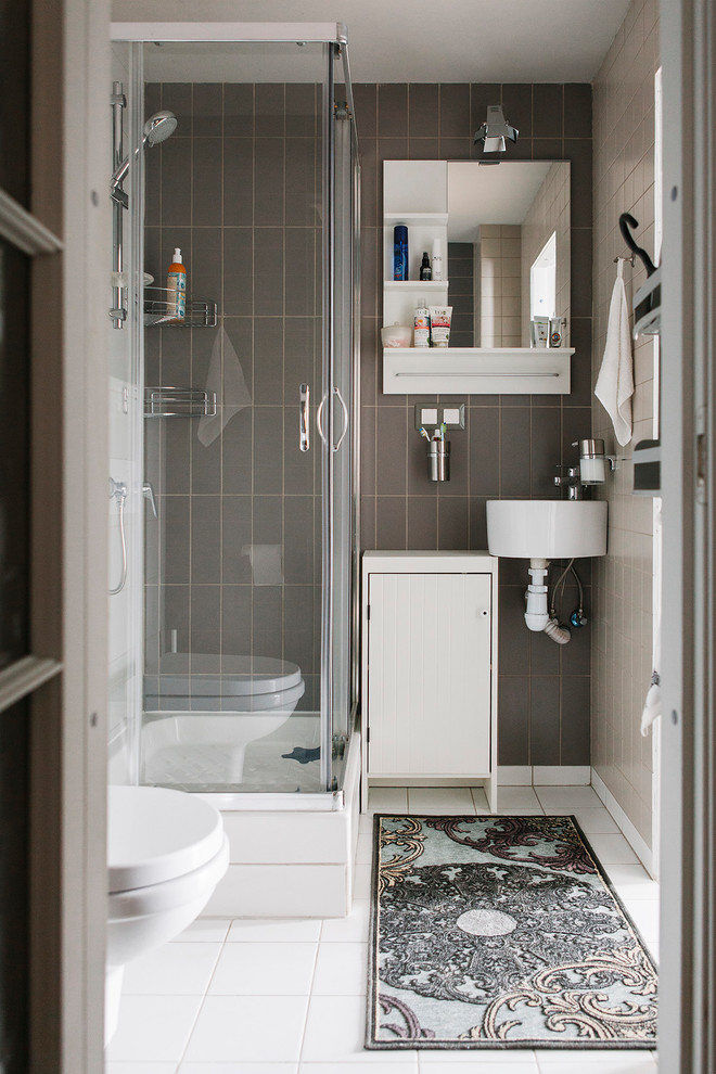 Idée de décoration pour une salle d'eau design avec un placard à porte plane, des portes de placard blanches, une douche d'angle, un carrelage marron, un carrelage gris, un lavabo suspendu, un sol blanc et une cabine de douche à porte coulissante.