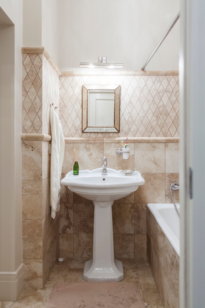 Идея дизайна: ванная комната в классическом стиле с ванной в нише, душем над ванной, бежевой плиткой, раковиной с пьедесталом и шторкой для ванной