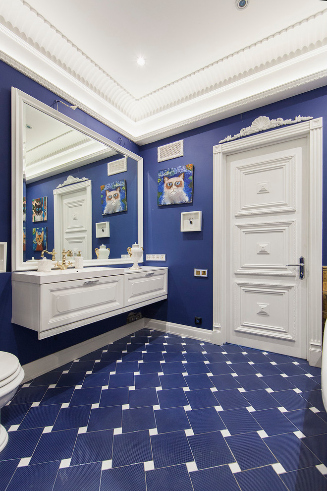 Cette photo montre une salle de bain principale chic avec un carrelage bleu, un mur bleu, un placard avec porte à panneau surélevé, des portes de placard blanches et un lavabo intégré.