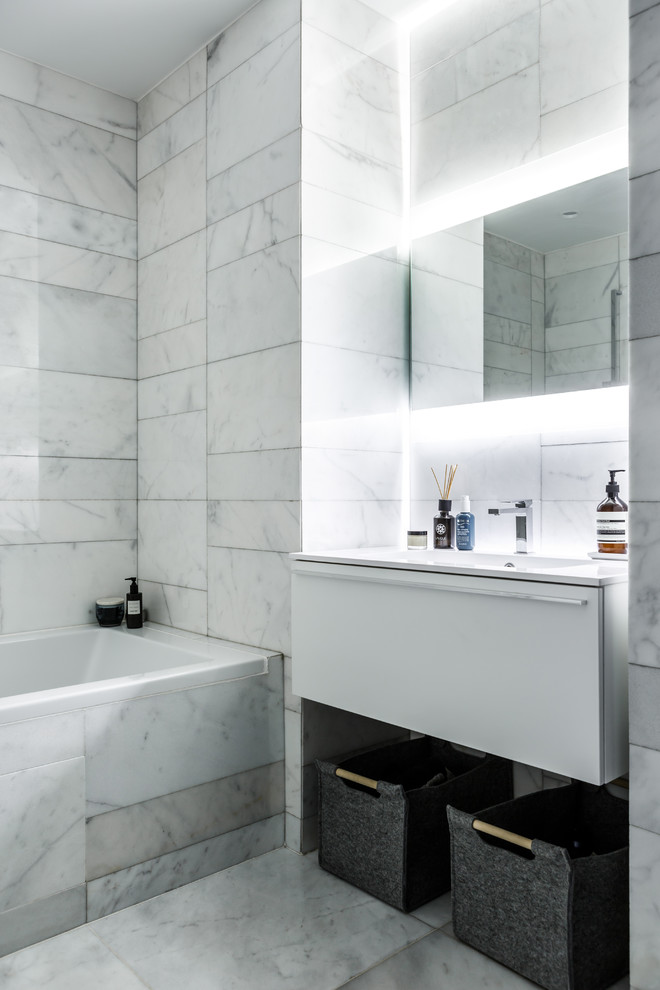 Свежая идея для дизайна: главная ванная комната в современном стиле с плоскими фасадами, белыми фасадами, ванной в нише, белой плиткой, мраморной плиткой, мраморным полом, монолитной раковиной, белым полом и акцентной стеной - отличное фото интерьера
