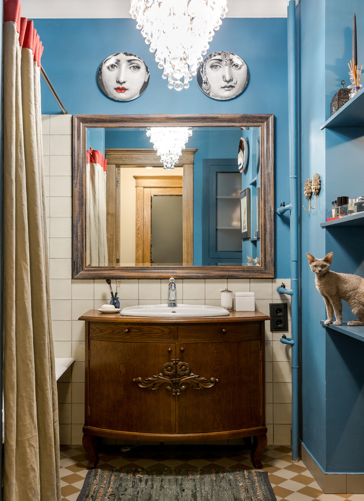 На фото: главная ванная комната в стиле фьюжн с темными деревянными фасадами, душем над ванной, белой плиткой, синими стенами, накладной раковиной, столешницей из дерева, коричневым полом, шторкой для ванной и коричневой столешницей