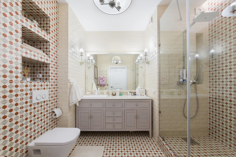 На фото: ванная комната среднего размера в современном стиле с фасадами с филенкой типа жалюзи, серыми фасадами, душем в нише, инсталляцией, разноцветной плиткой, плиткой кабанчик, полом из цементной плитки, душевой кабиной, накладной раковиной, столешницей из искусственного камня, разноцветным полом и душем с распашными дверями с