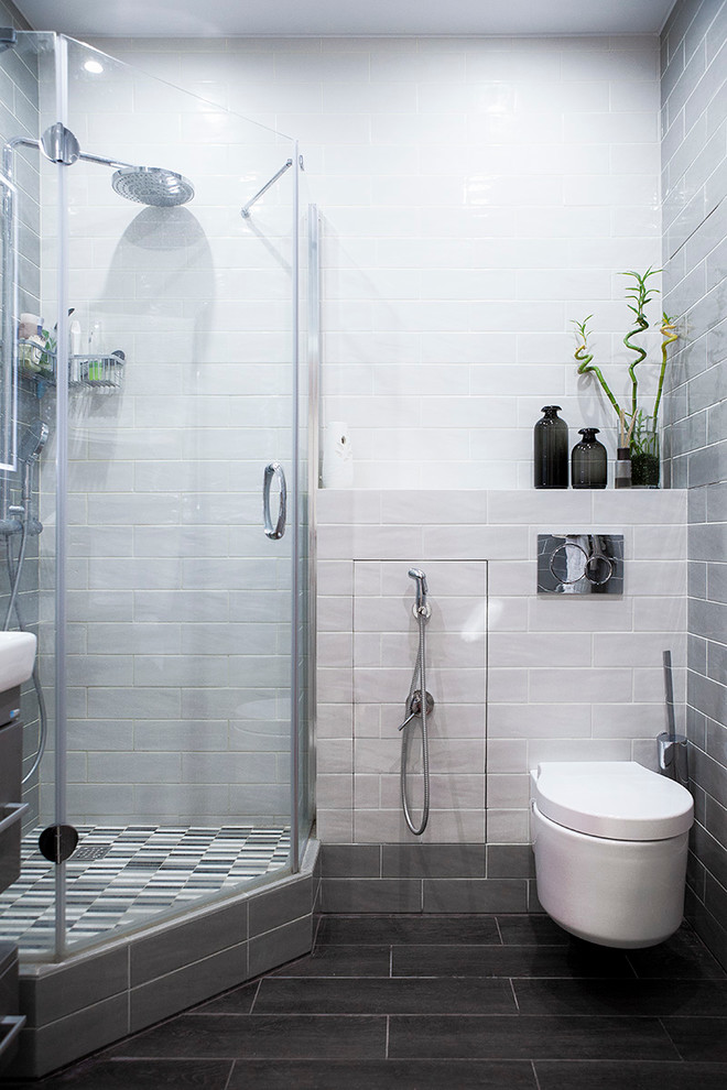 Bild på ett funkis badrum med dusch, med en hörndusch, en vägghängd toalettstol, klinkergolv i porslin, vit kakel och svart kakel