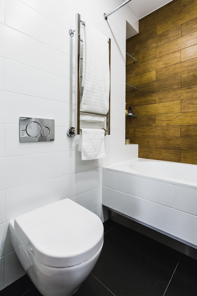 На фото: главная ванная комната в современном стиле с ванной в нише, инсталляцией и белой плиткой с