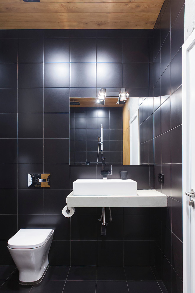 Ejemplo de cuarto de baño contemporáneo con sanitario de dos piezas, baldosas y/o azulejos negros y lavabo sobreencimera