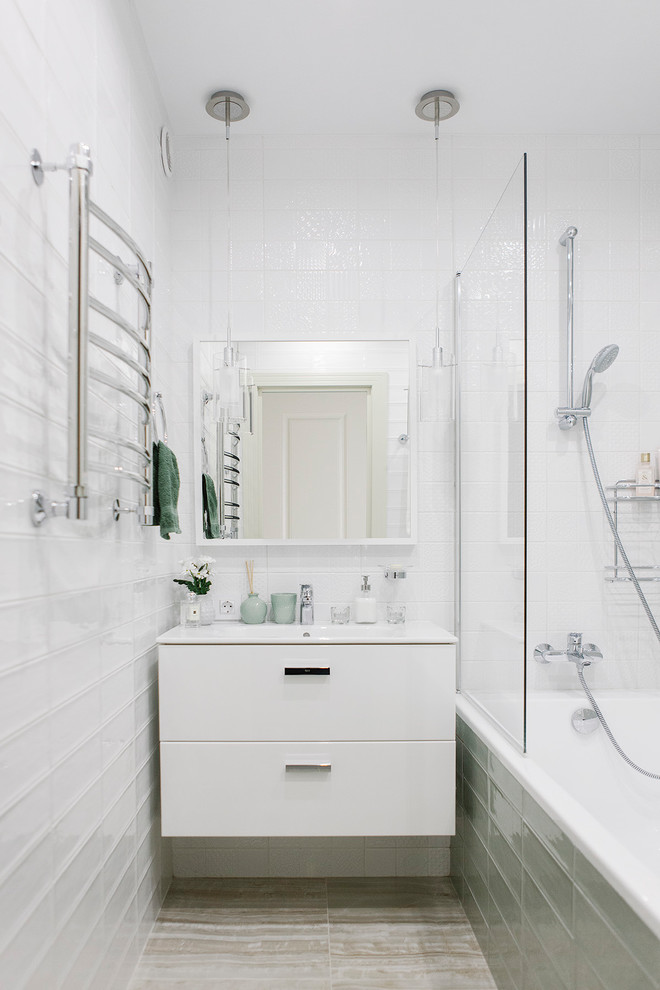 Пример оригинального дизайна: маленькая главная ванная комната в современном стиле с плоскими фасадами, белыми фасадами, ванной в нише, душем над ванной, белой плиткой, зеленой плиткой и монолитной раковиной для на участке и в саду