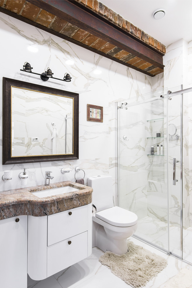 На фото: ванная комната в стиле фьюжн с плоскими фасадами, белыми фасадами, душем в нише, раздельным унитазом, белой плиткой, душевой кабиной, врезной раковиной, белым полом и душем с раздвижными дверями с