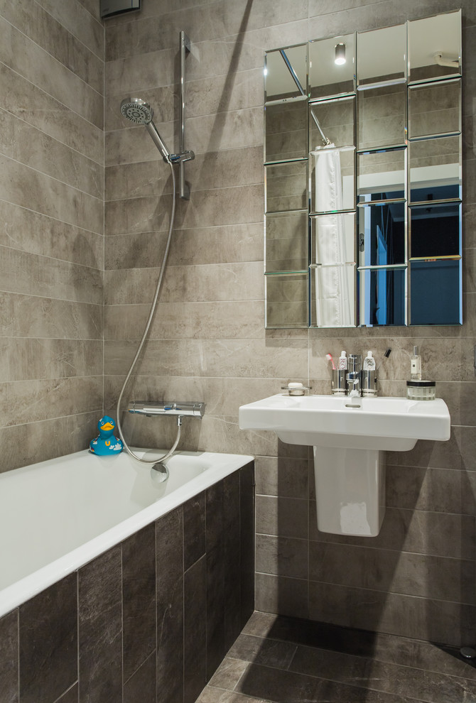 Idée de décoration pour une salle de bain principale design avec une baignoire en alcôve, un combiné douche/baignoire, un carrelage gris, un lavabo suspendu, un sol gris et une cabine de douche avec un rideau.
