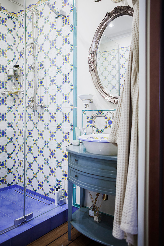 Ejemplo de cuarto de baño clásico con armarios con paneles empotrados, puertas de armario azules, baldosas y/o azulejos multicolor, paredes blancas, aseo y ducha, lavabo sobreencimera y ducha con puerta con bisagras