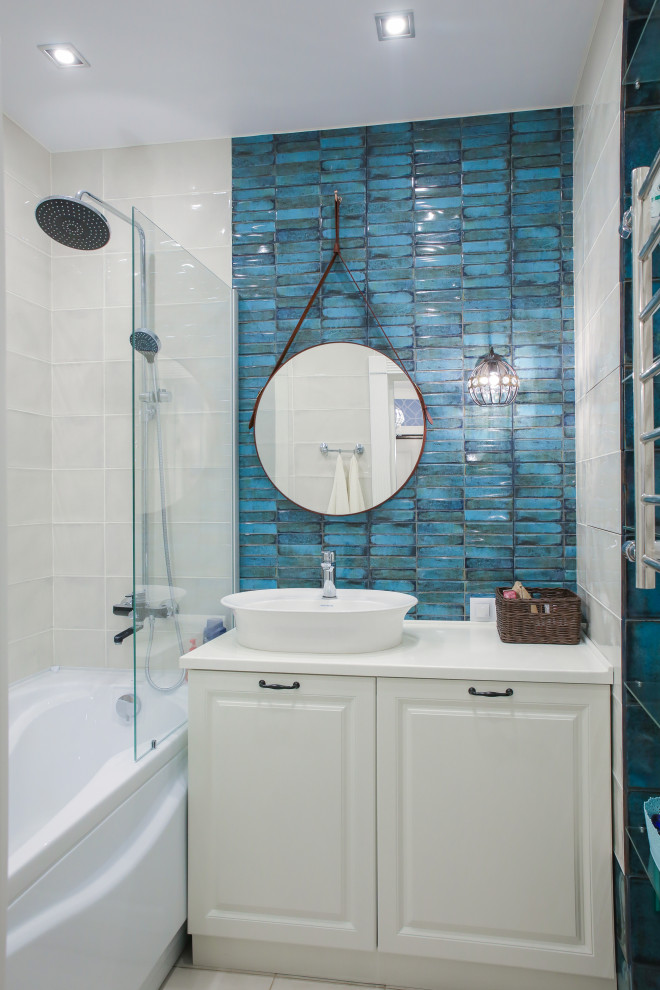 Стильный дизайн: главная ванная комната среднего размера в стиле неоклассика (современная классика) с керамической плиткой, настольной раковиной, столешницей из искусственного камня, белой столешницей, фасадами с выступающей филенкой, белыми фасадами, душем над ванной, бежевой плиткой, синей плиткой, открытым душем, тумбой под одну раковину, ванной в нише и напольной тумбой - последний тренд
