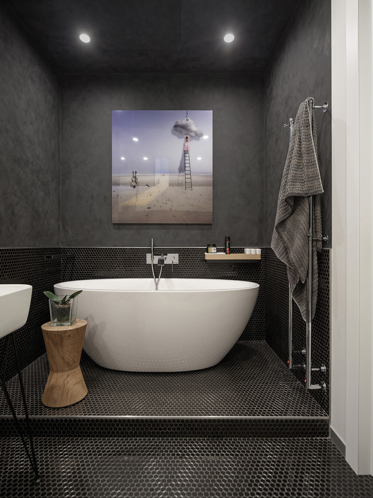 Modelo de cuarto de baño actual con paredes negras, suelo de baldosas de cerámica, suelo negro y bañera exenta
