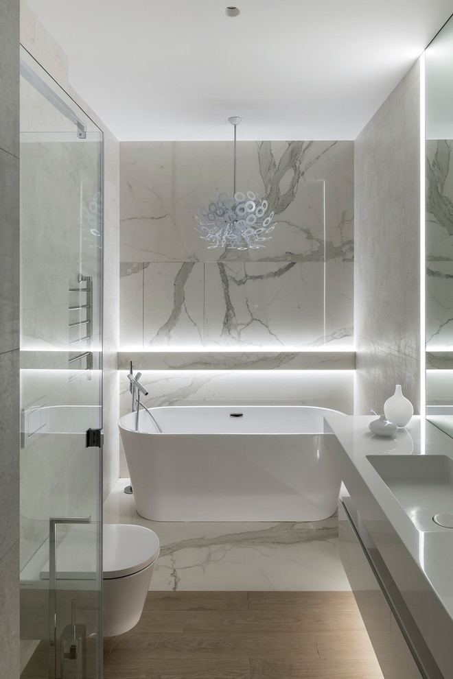 На фото: главная ванная комната в современном стиле с отдельно стоящей ванной и монолитной раковиной