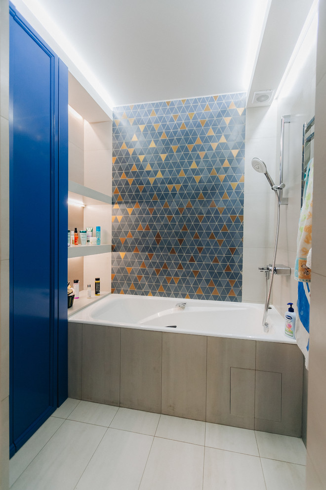 Exempel på ett litet klassiskt en-suite badrum, med luckor med upphöjd panel, blå skåp, ett undermonterat badkar, en dusch/badkar-kombination, beige kakel, keramikplattor, beige väggar, klinkergolv i keramik och beiget golv