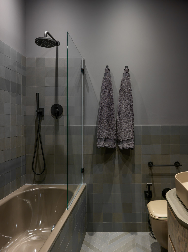 Immagine di una piccola stanza da bagno design con vasca/doccia, piastrelle grigie, pareti grigie, pavimento con piastrelle in ceramica, lavabo a bacinella, pavimento grigio, doccia aperta, ante beige, top beige e vasca ad alcova