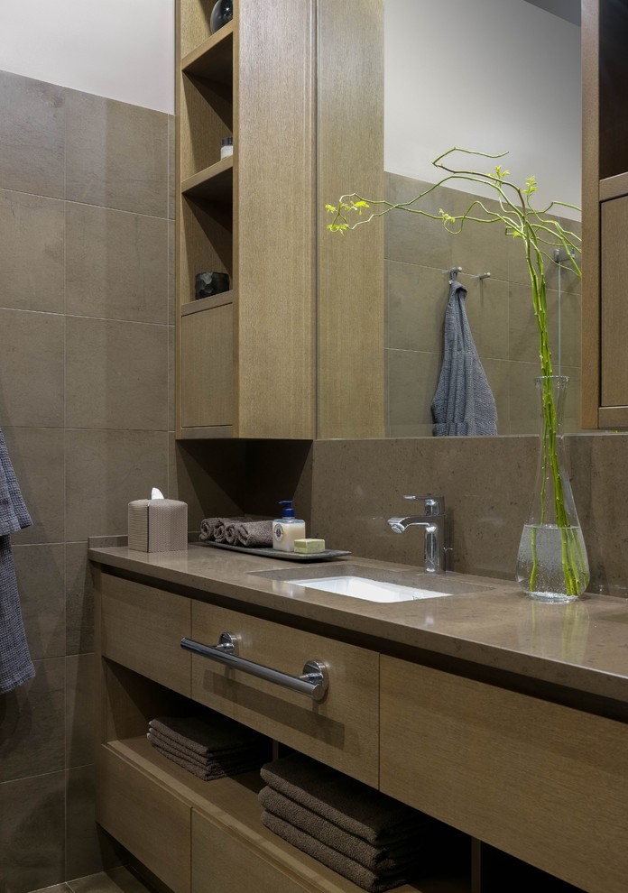Cette image montre une salle de bain design en bois brun de taille moyenne avec un placard à porte plane, un carrelage beige, un plan de toilette en quartz et un plan de toilette beige.