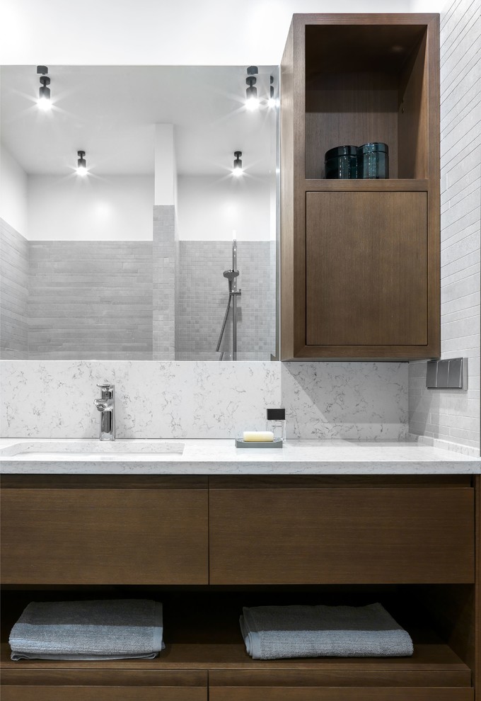 На фото: ванная комната среднего размера в современном стиле с плоскими фасадами, серой плиткой, душевой кабиной, керамогранитной плиткой, столешницей из кварцита, белой столешницей, темными деревянными фасадами и врезной раковиной с