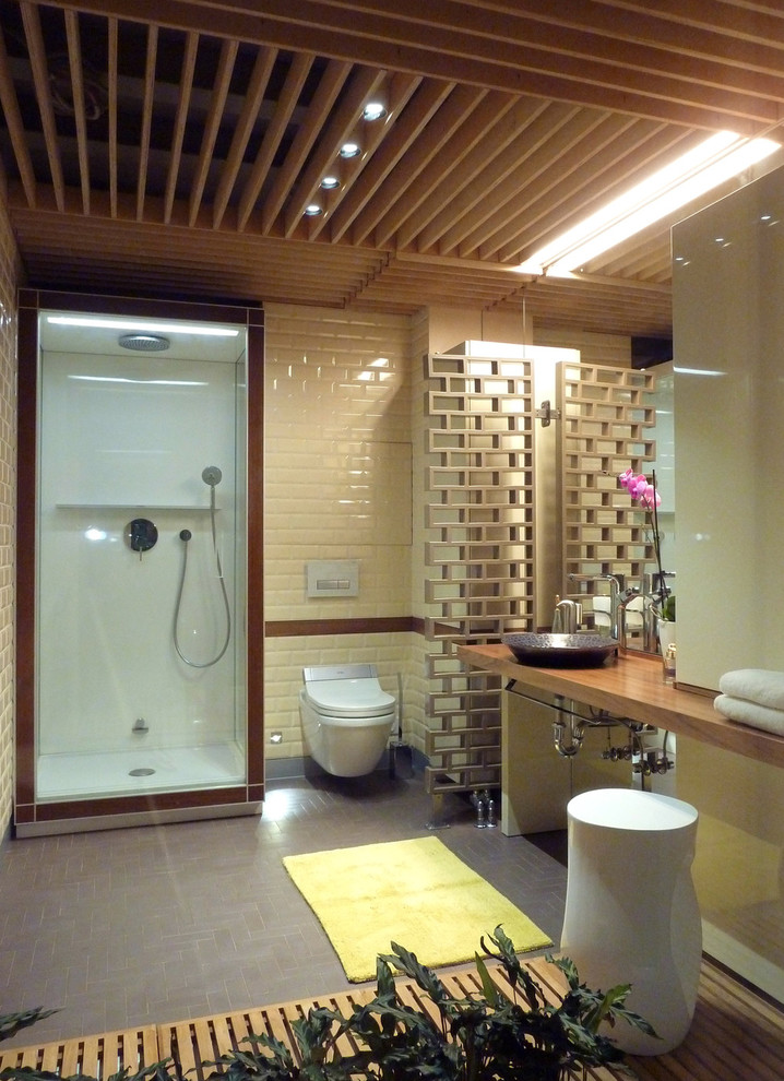 Ejemplo de cuarto de baño contemporáneo con baldosas y/o azulejos beige, baldosas y/o azulejos de cerámica, paredes beige, suelo de azulejos de cemento, encimera de madera y lavabo sobreencimera