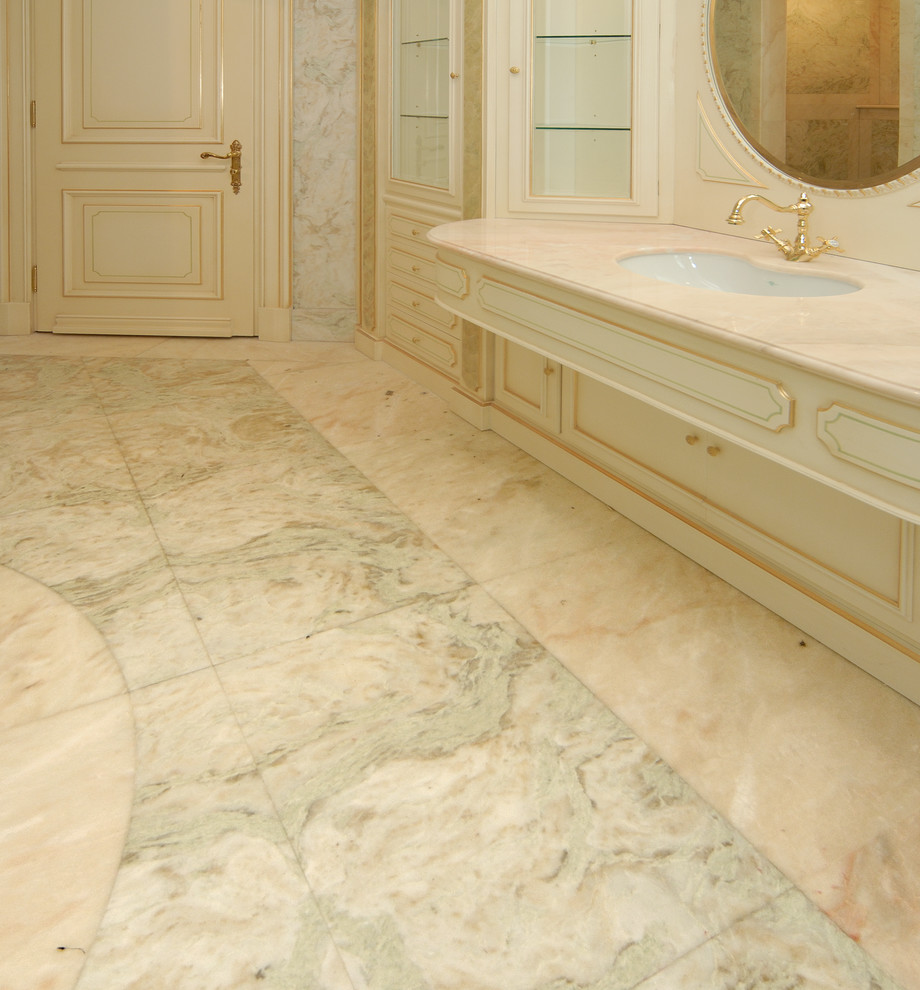 Пример оригинального дизайна: огромная главная ванная комната в классическом стиле с фасадами с выступающей филенкой, бежевыми фасадами, бежевой плиткой, мраморной плиткой, розовыми стенами, мраморным полом, врезной раковиной, столешницей из оникса, розовым полом и розовой столешницей
