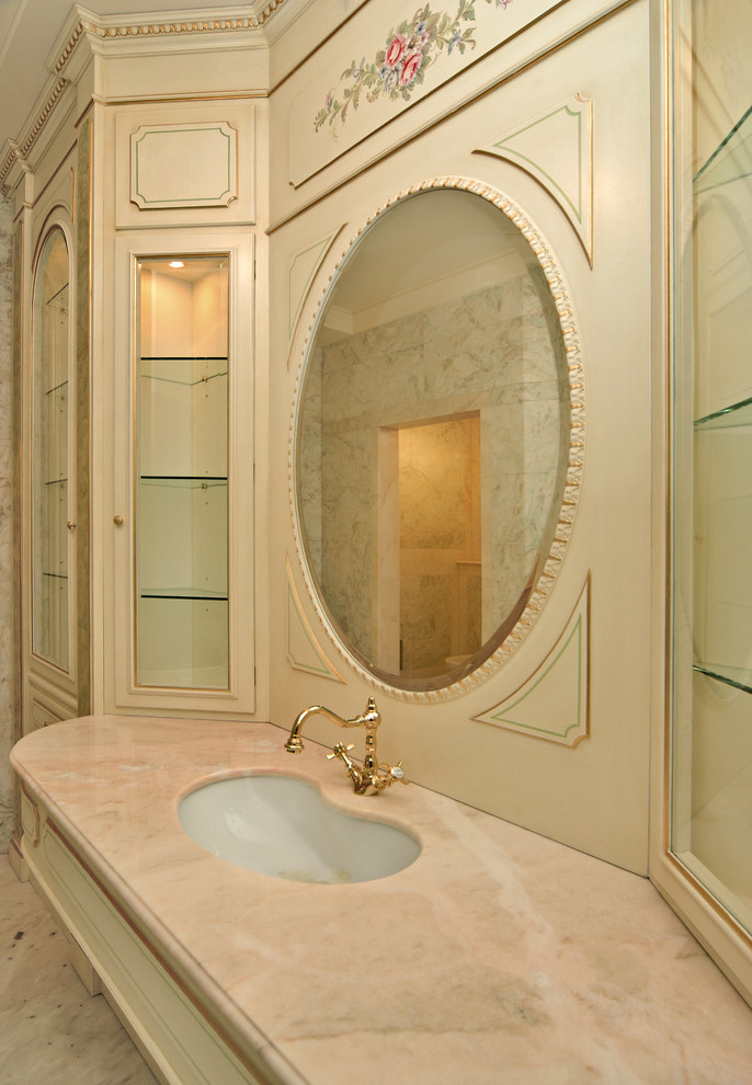 Exempel på ett mycket stort klassiskt rosa rosa en-suite badrum, med luckor med upphöjd panel, beige skåp, beige kakel, marmorkakel, rosa väggar, marmorgolv, ett undermonterad handfat, bänkskiva i onyx och rosa golv