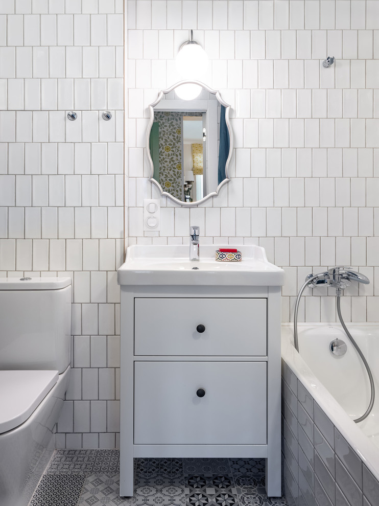На фото: маленькая главная ванная комната в стиле ретро с плоскими фасадами, белыми фасадами, полновстраиваемой ванной, душем над ванной, унитазом-моноблоком, белой плиткой, керамической плиткой, синими стенами, полом из керамогранита, настольной раковиной, серым полом и шторкой для ванной для на участке и в саду с