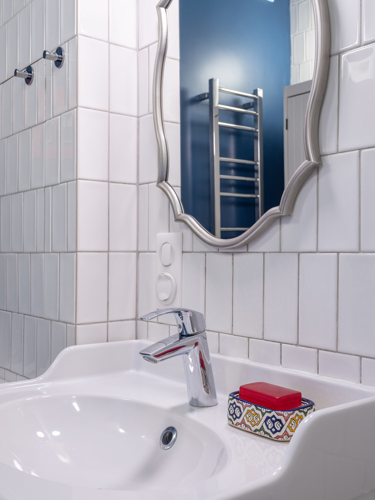 Idéer för ett litet 50 tals en-suite badrum, med släta luckor, vita skåp, ett undermonterat badkar, en dusch/badkar-kombination, en toalettstol med hel cisternkåpa, vit kakel, keramikplattor, blå väggar, klinkergolv i porslin, ett fristående handfat, grått golv och dusch med duschdraperi