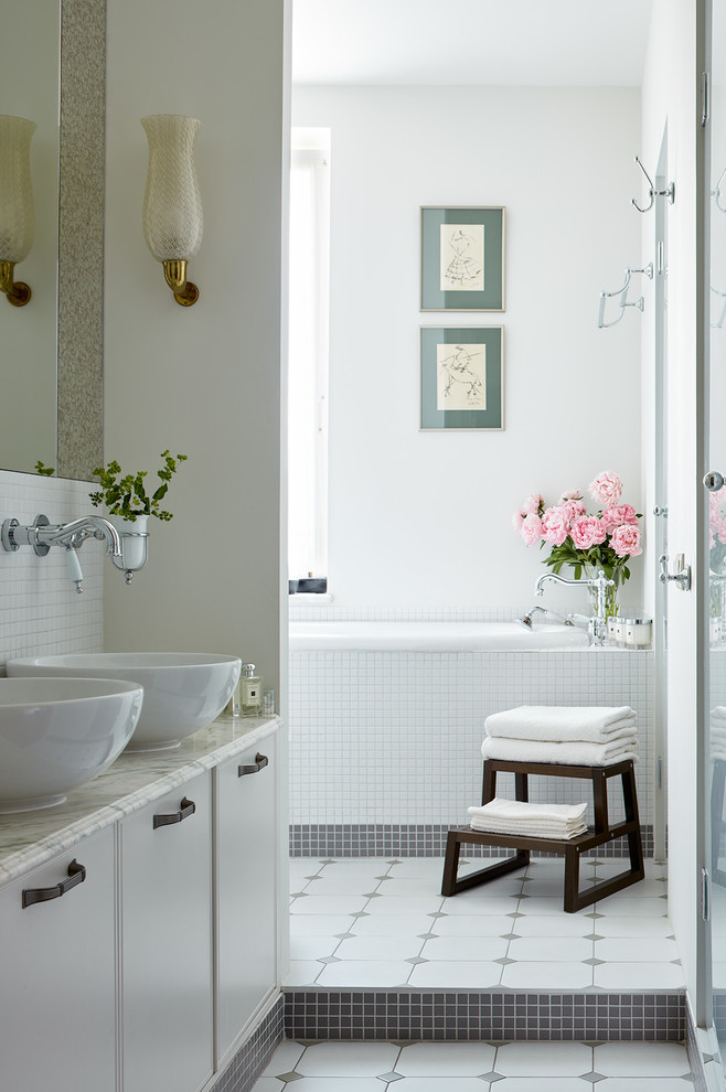 Cette image montre une salle de bain principale traditionnelle avec un placard à porte affleurante, des portes de placard blanches, une baignoire en alcôve, un carrelage blanc, mosaïque, un mur blanc, une vasque, un sol multicolore et un plan de toilette gris.