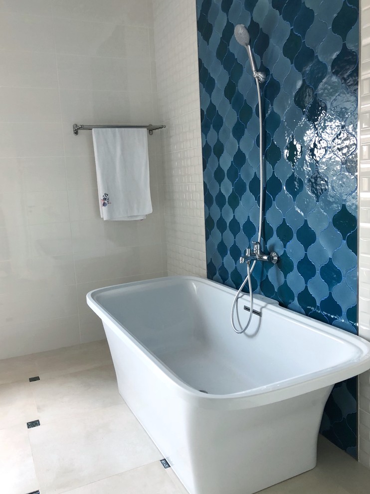 Diseño de cuarto de baño principal contemporáneo de tamaño medio con armarios con paneles lisos, puertas de armario blancas, bañera exenta, combinación de ducha y bañera, baldosas y/o azulejos multicolor, baldosas y/o azulejos de cerámica, paredes blancas, suelo de baldosas de porcelana, encimera de mármol, suelo gris, ducha abierta, encimeras blancas y lavabo sobreencimera