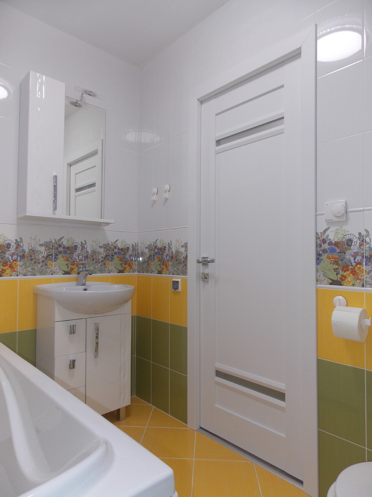 Idées déco pour une petite salle de bain principale éclectique avec un placard à porte vitrée, des portes de placard blanches, une baignoire sur pieds, WC à poser, un carrelage multicolore, des carreaux de céramique, un mur multicolore, un sol en carrelage de céramique, un lavabo posé, un sol jaune et un plan de toilette blanc.