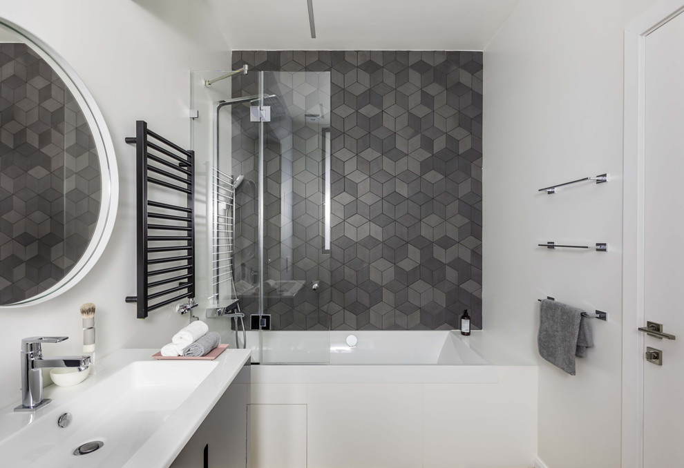 Пример оригинального дизайна: главная ванная комната среднего размера в скандинавском стиле с плоскими фасадами, черными фасадами, накладной ванной, душем над ванной, серой плиткой, керамической плиткой, белыми стенами и монолитной раковиной