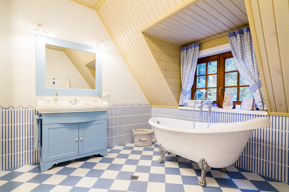 Exempel på ett lantligt badrum, med skåp i shakerstil, blå skåp, ett badkar med tassar, blå kakel, vit kakel, flerfärgat golv, flerfärgade väggar och ett konsol handfat