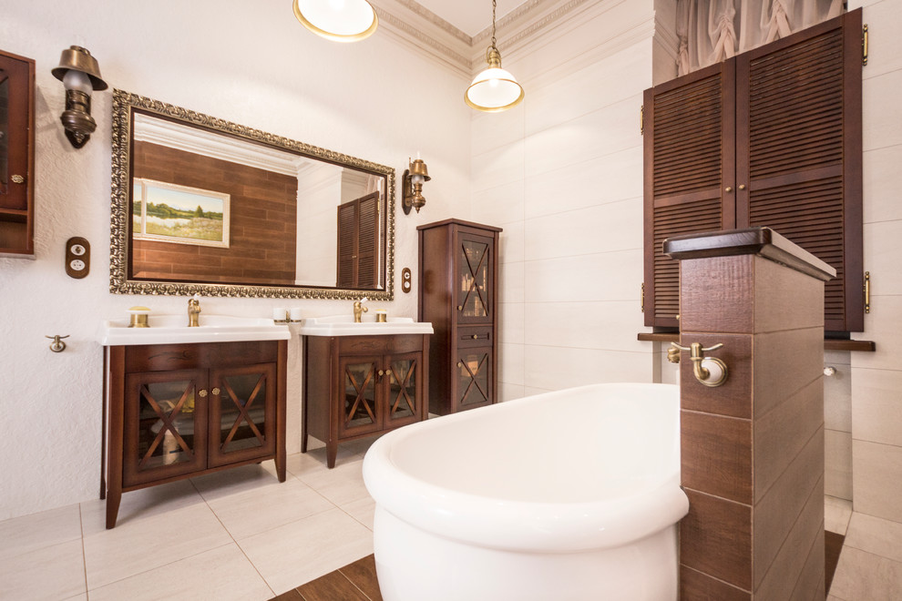 Idéer för stora medelhavsstil en-suite badrum, med ett fristående badkar, en vägghängd toalettstol och beige kakel