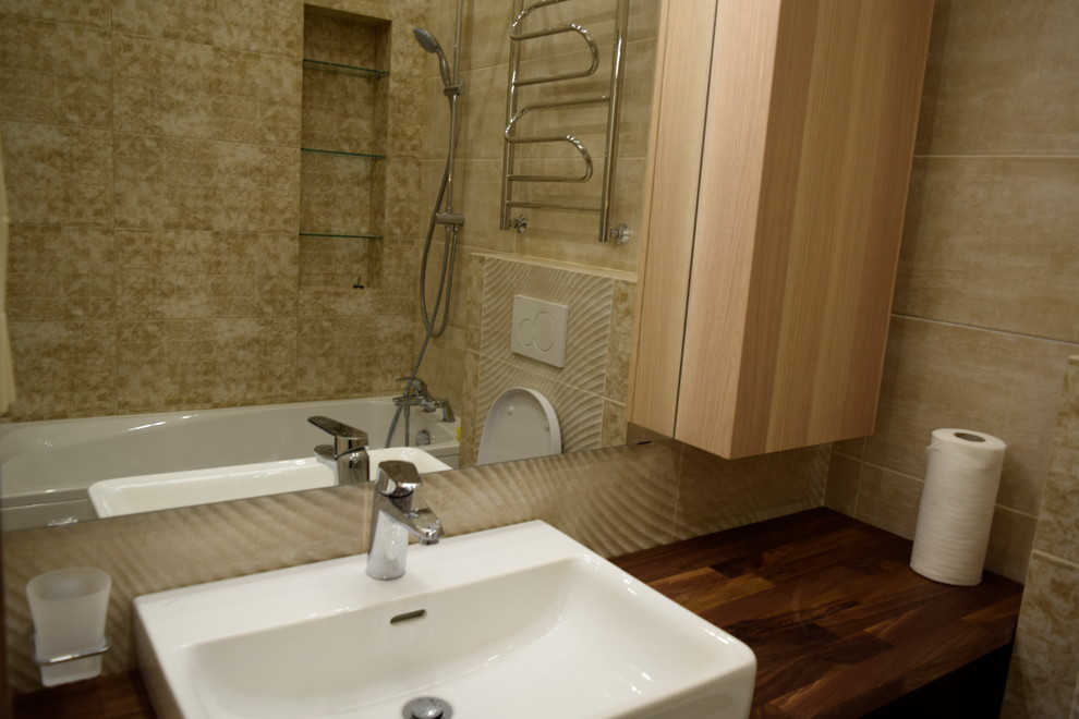 Пример оригинального дизайна: главная ванная комната среднего размера в современном стиле с открытыми фасадами, темными деревянными фасадами, полновстраиваемой ванной, инсталляцией, бежевой плиткой, керамической плиткой, бежевыми стенами, полом из керамической плитки, настольной раковиной, столешницей из дерева, бежевым полом, открытым душем и коричневой столешницей