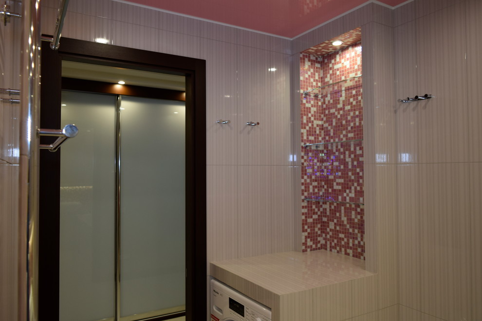 На фото: большая главная ванная комната в стиле неоклассика (современная классика) с плоскими фасадами, бежевыми фасадами, полновстраиваемой ванной, инсталляцией, розовой плиткой, керамической плиткой, бежевыми стенами, полом из керамической плитки, мраморной столешницей, розовым полом, открытым душем, бежевой столешницей, подвесной раковиной и акцентной стеной с