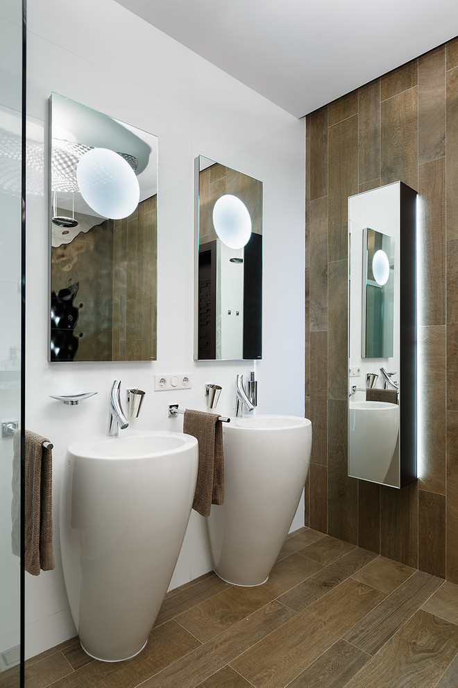 Diseño de cuarto de baño principal actual con baldosas y/o azulejos marrones, paredes blancas, lavabo con pedestal y espejo con luz