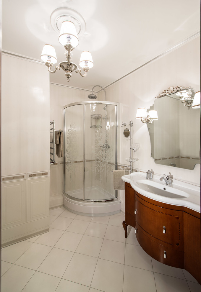 Klassisk inredning av ett mellanstort badrum med dusch, med en hörndusch, vit kakel, vita väggar, klinkergolv i keramik, ett integrerad handfat, skåp i mellenmörkt trä och dusch med skjutdörr