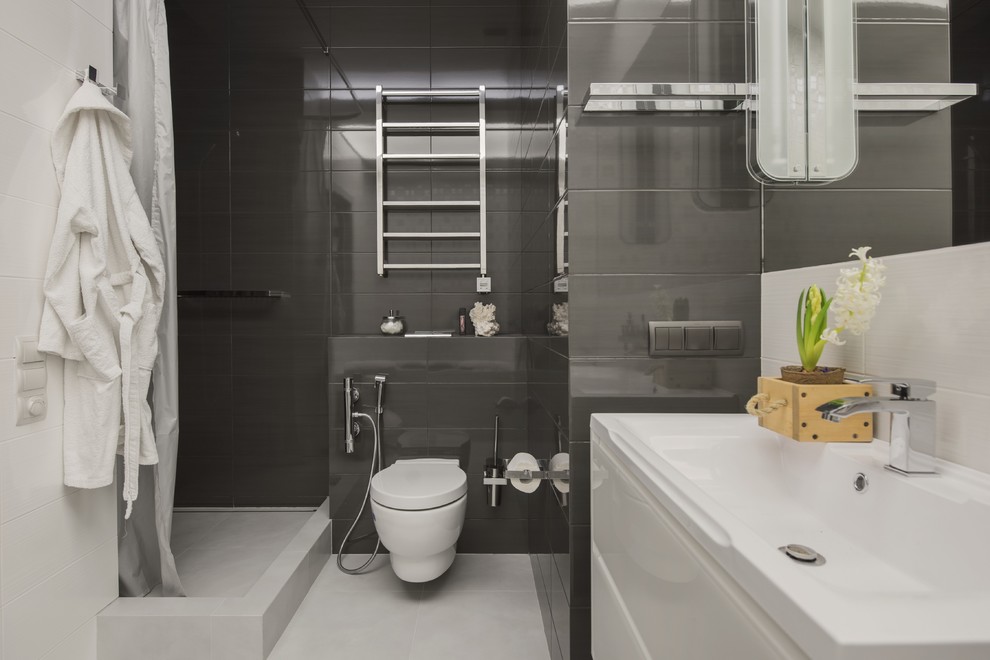 Идея дизайна: маленькая ванная комната в современном стиле с плоскими фасадами, белыми фасадами, угловым душем, инсталляцией, керамической плиткой, полом из керамогранита, душевой кабиной, столешницей из искусственного камня, белым полом, шторкой для ванной, монолитной раковиной, гигиеническим душем, черно-белой плиткой, тумбой под одну раковину и подвесной тумбой для на участке и в саду
