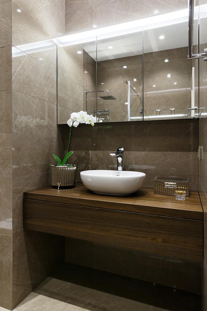 Modelo de cuarto de baño actual de tamaño medio con puertas de armario de madera en tonos medios, baldosas y/o azulejos de cerámica, suelo de baldosas de porcelana y lavabo sobreencimera